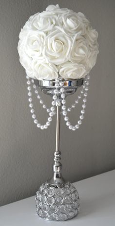 a white rose and crystal beaded candelabra with pearls on the base