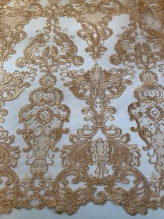 gold and white fabric with intricate design on it