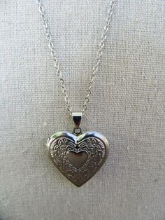 90s silver tone chain with heart locket. Lobster claw closure. Lightweight, costume jewelry. Very cute.  Chain is 20" Locket opens and closes and measures 1-1/8" x 1-1/8" Some light scuffing on underside, otherwise good with no other noted flaws. Vintage Heart Pendant Locket Necklace With Adjustable Chain, Metal Heart Pendant Locket Charm Necklace, Silver Nickel-free Locket Necklace For Valentine's Day, Valentine's Day Silver Locket Necklace, Nickel Free, Valentine's Day Silver Locket Necklace Nickel Free, Silver Heart Locket Necklace With Adjustable Chain, Silver Heart-shaped Locket Necklace With Adjustable Chain, Vintage Heart Locket Necklace With Adjustable Chain, Nickel-free Metal Heart Pendant Locket Necklace