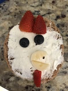 a piece of bread with fruit on it and a face made to look like a chicken