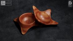 two wooden bowls sitting on top of a black countertop next to an empty container