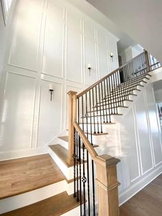 a staircase in a house with white walls and wood floors