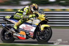 a man riding on the back of a yellow motorcycle