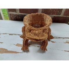 a small wicker basket sitting on top of a white table next to a brick wall