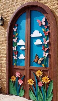 an open door with paper flowers and butterflies on the glass, in front of a brick wall