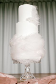 a white wedding cake with feathers on top