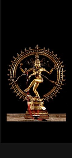 a golden statue is displayed on a black background with an intricate border around the base