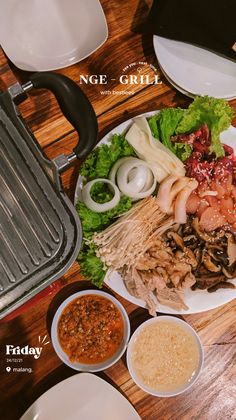 a plate full of food sitting on top of a wooden table next to plates and bowls