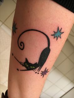 a black cat sitting on top of a person's leg with stars around it