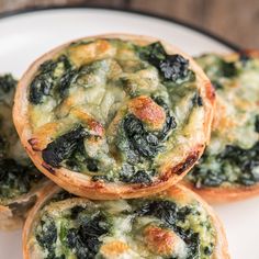 three mini quiches with spinach and cheese on a plate