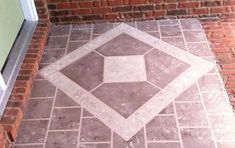 a brick walkway with a diamond shaped design on the ground in front of a door