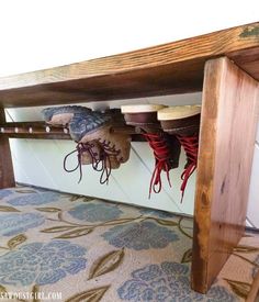 a wooden bench with shoes hanging from it's sides and on the bottom shelf