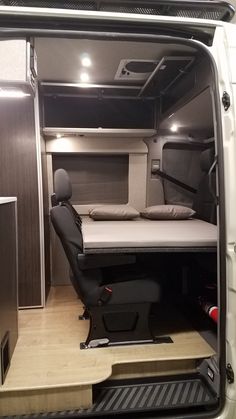 the interior of a camper van with its bed in the back and stairs to the side