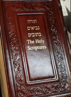 an old book with hebrew writing on the front and back cover, sitting on top of a table