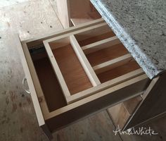 an open drawer in the middle of a kitchen counter