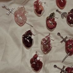 there are many heart shaped glass ornaments on the table together, including one with a cross