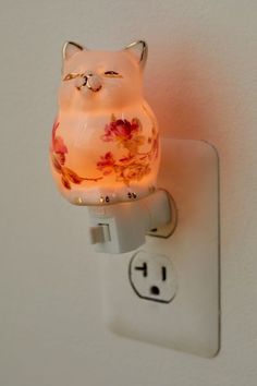 a light that is on the side of a wall with a cat figurine