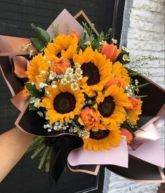 a bouquet of sunflowers and baby's breath in front of a door