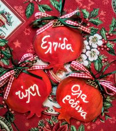 three red ornaments with white writing on them