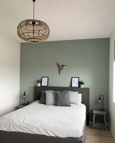 a bed sitting in a bedroom under a light fixture