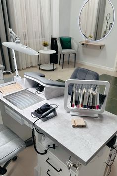 an office desk with several different items on it and a mirror in the corner behind it