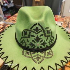 Green fedora that has been burned and painted. Green Fedora For Kentucky Derby, Green Hat Bands For Kentucky Derby, Green Wide Brim Felt Hat For Festival, Adjustable Green Wide Brim Fedora, Green Bohemian Hat Bands For Spring, Casual Green Fedora With Curved Brim, Green Adjustable Wide Brim Fedora, Adjustable Green Wide-brim Fedora, Bohemian Green Fedora For Festivals