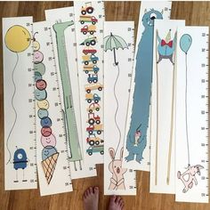 four children's growth chart books on a wooden floor with their feet propped up next to them