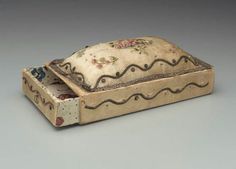 an old box with a floral design on the lid and inside is sitting on a gray surface