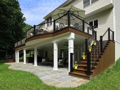 a deck with stairs and railings in front of a house