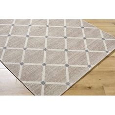 a beige and grey rug on top of a wooden floor