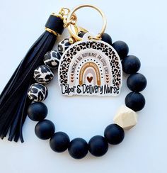 a black and white beaded bracelet with a tassel on the end that says labore's dairy wives