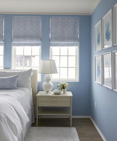 a bedroom with blue walls and white bedding