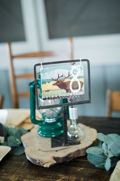 a wooden table topped with a glass vase filled with water and an antelope