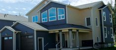 two story house with multiple garages in the front yard