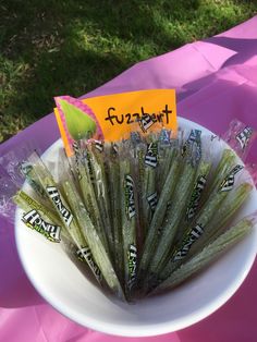 there is a white bowl with some candy on it and a sign that says fuzznuts