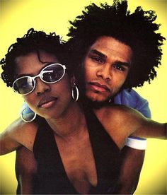 a man and woman with sunglasses on their heads posing for a photo together in front of a yellow background