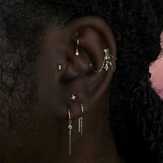 a close up of a woman's ear with three different types of piercings