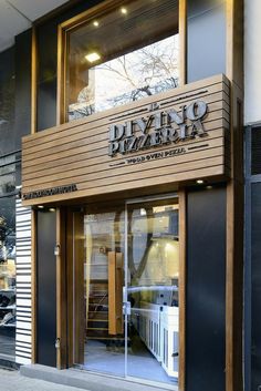 the entrance to a building with wooden panels and glass doors that read, diego benzzeria