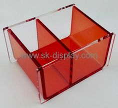 a red plastic box with two compartments on the front and one in the back, sitting on a white surface