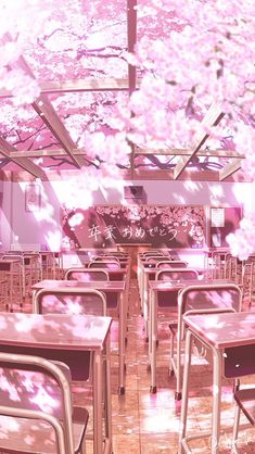 an empty classroom with pink flowers on the ceiling and tables in front of it,