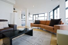 a living room filled with furniture and large windows