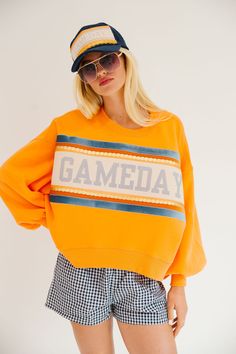 Take your gameday look up a notch with our GAMEDAY ORANGE PULLOVER. Made with a vibrant orange crop design and accented with a blue, gold, and white striped ribbon featuring a playful blue Gameday design. It's the perfect way to show off your team spirit with style. Go team! All orders are currently shipping within 14 business days. To receive item quicker, expedited shipping is available at checkout. Purple And Gold Gameday Outfit, Gameday Design, Orange Games, Crop Design, Orange Pullover, Game Outfit, Football Game Outfit, Go Team, Striped Ribbon