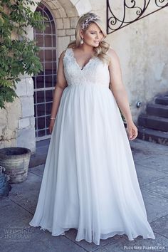 a woman in a white dress standing outside