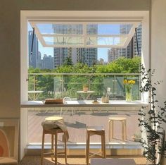 a living room filled with furniture and a large window overlooking a cityscape in the distance