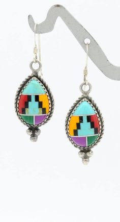 For your consideration, we are offering a colorful pair of sterling silver earrings featuring cabochons constructed from a beautiful Southwestern mosaic inlay of turquoise, black onyx, malachite, sugilite, and coral.  Thank you for your interest! Weight:  6.48 gr Size of Each Cabochon:  14mm  x  10mm Drop Length:  1  7/16 inch Charm Length:  1 inch Charm Width:  1/2 inch Hallmarks: 5 * (Star), STER ** Due to USPS changes, standard shipping may take a few extra days.  If you would like a faster delivery time, we have added a new express shipping option.** Please feel free to reach out with any questions you might have about this item. **Please Note ~ The props used for photos will not be included.** We test all our vintage jewelry for karat content as well as gem testing when applicable. We Mosaic Earrings, Mosaic Inlay, Star Signs, Black Onyx, Precious Metals, Sterling Silver Earrings, 5 Star, Jewelry Earrings Dangle, Onyx