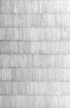 a black and white photo of a wall made out of thin strips of paper with an umbrella