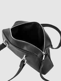 A stunning blend of past and present fashion trends, the JAMIE bowling bag exudes a captivatingly dark and edgy design. Crafted from supple pebbled black leather, it features piercing-like handle attachments, pull tabs, organic cotton twill lining, and twin-headed zippers with tassel pulls. With dimensions of L11.5 x H6.5 x W3" and a strap drop of 9", this bag is the perfect balance of sophistication and nostalgia. Black Satchel With Round Handles, Modern Leather Duffle Bag With Handles, Modern Black Satchel With Round Handle, Top Handle Satchel With Gunmetal Hardware, Modern Top Handle Satchel With Gunmetal Hardware, High School Years, Edgy Design, Trendy Bags, Bowling Bag