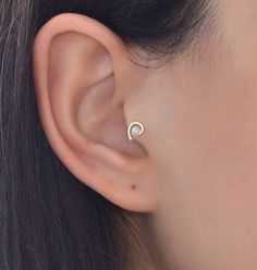 a woman's ear is shown with a single diamond in the middle