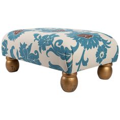 a blue and white ottoman with gold wheels on the bottom, sitting in front of a white background