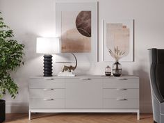 a living room scene with focus on the sideboard and two vases sitting on top of it